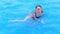 A child in a swimsuit and a water mask swims in the pool of the water park.