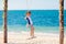 Child on swing. Kid swinging on beach