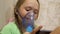 Child with tablet is sick and breathes through an inhaler. close-up. little girl treated with an inhalation mask on her