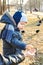 A child takes pumpkin seeds from her mother`s hand to feed the birds in the park in early spring