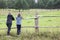 Child talking to her mother in the field. Standing near green field and looking at calm nature, copyspace