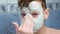 Child teen boy is applying alginate mask lying in bathroom with foam at home.