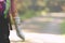 A child or teenage kid with its forearm in plaster cast goes hiking happily on a forest path lying in bright sun light.