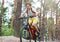 Child teenager in white t shirt and yellow shorts on bicycle ride in forest at spring or summer. Happy smiling Boy cycling
