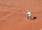 Child tennis player on a clay court. A boy plays tennis on an outdoor tennis court. Kids tournament. Copy space