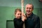 A child with a terener doing gymnastic exercises. Grandfather teaches his granddaughter to climb a rope in the gym. The coach is