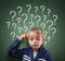 Child thinking with question mark on blackboard