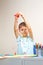 Child throwing small piece of colored paper as confetti after he created greeting card