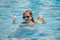 Child with thumbs up in sunglasses relax in summer swimming pool. Active kids healthy lifestyle, water sport activity