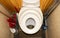 A child toilet seat on the toilet.An old dirty toilet.Toilet bowl with a small hole for coping needs.