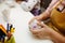 A child in training at home during quarantine makes origami out of paper. children`s creativity. hands close up