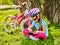 Child traveling bicycle in summer park. Girl watch tablet computer.