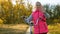 Child travels with a bicycle in the park. young girl walks. A young girl walks along the road and rides a bicycle