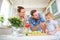 Child tries salad with parents in kitchen