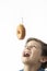 A child trying to bite a doughnut hanging from a hook