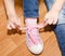 Child tying her shoes sitting on the floor