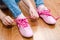 Child tying her shoes sitting on the floor at home