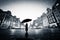 Child with umbrella standing alone on cobblestone old town in rain