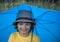 Child with an umbrella walks in the rain, happy boy with umbrella outdoors