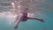 A child in an underwater mask learns to swim and dive. The boy dives into the sea