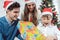 Child unwrapping Christmas present with his family