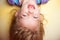 Child upside down against yellow background