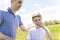 Child using inhaler for asthma outside in a park with his father