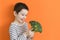 Child with vegetable broccoli orange background