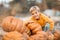 A child in the village has fun near the pumpkin crop