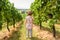 Child in vineyard, little girl looks at grape field, lonely kid at vine plantation