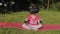 Child in VR headset helmet sitting in lotus position on mat and performing yoga meditation in park