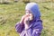 A child on a walk eats a sandwich on a spring sunny day.