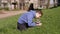 Child Walking a Fat Gray British Cat on a Leash in the Open Air in Thick Grass