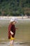 Child walking on fine sand through the water