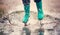 Child walking in wellies in puddle on rainy weather