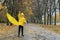 Child walks in the park and plays with an yellow umbrella. Walking with child in rain