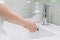 Child washes hands a small with soap over the sink with running water. Personal hygiene. Protection against COVID-19