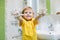 Child washing hands and showing soapy palms