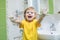 Child washing hands and showing soapy palms