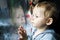 Child watching the rain on window