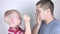 The child waves his fists and yells at his father. Child aggression, family conflicts, a crisis of three to four years. Children`s