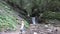 Child Waving Goodbye by Waterfall, Kid View in Mountains, Tourist Girl in Forest