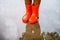 Child wearing orange rain boots