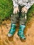 Child wearing rain boots , sits at muddy puddle