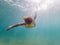 Child wearing snorkeling mask diving underwater