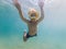 Child wearing snorkeling mask diving underwater