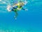 Child wearing snorkeling mask diving underwater