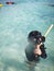 Child wearing snorkeling mask in the water.