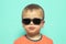 Child wearing sunglasses with a serious attitude
