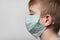 Child wears medical mask to protect from germs. Portrait Side view